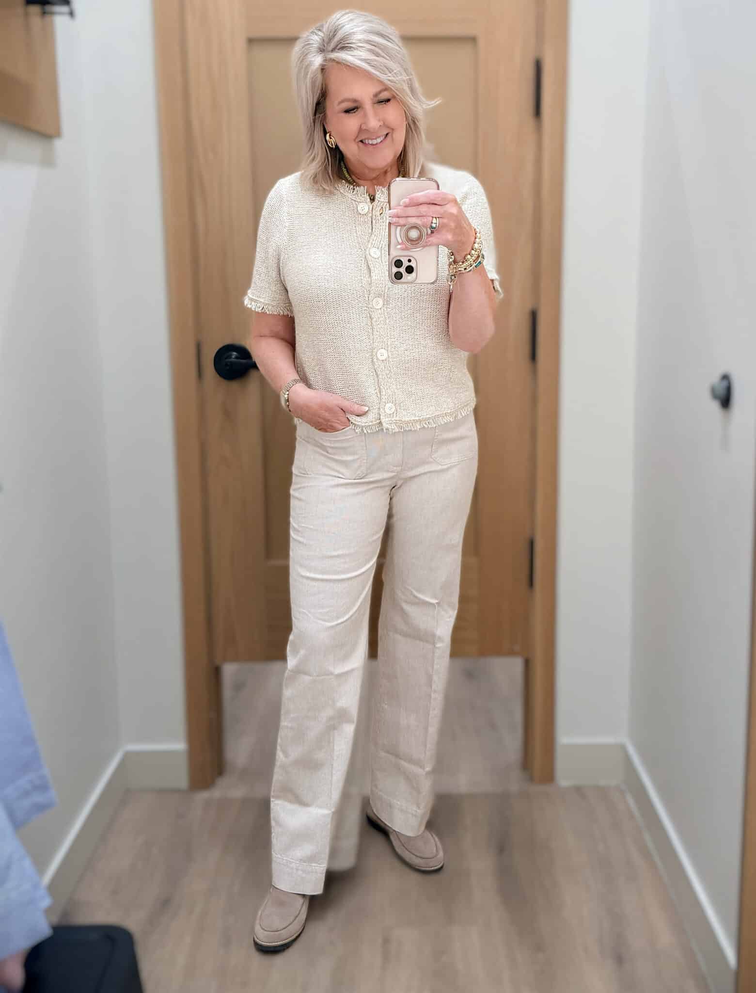 Tania wearing a beige fringed cardigan with beige striped pants from J.Crew Factory