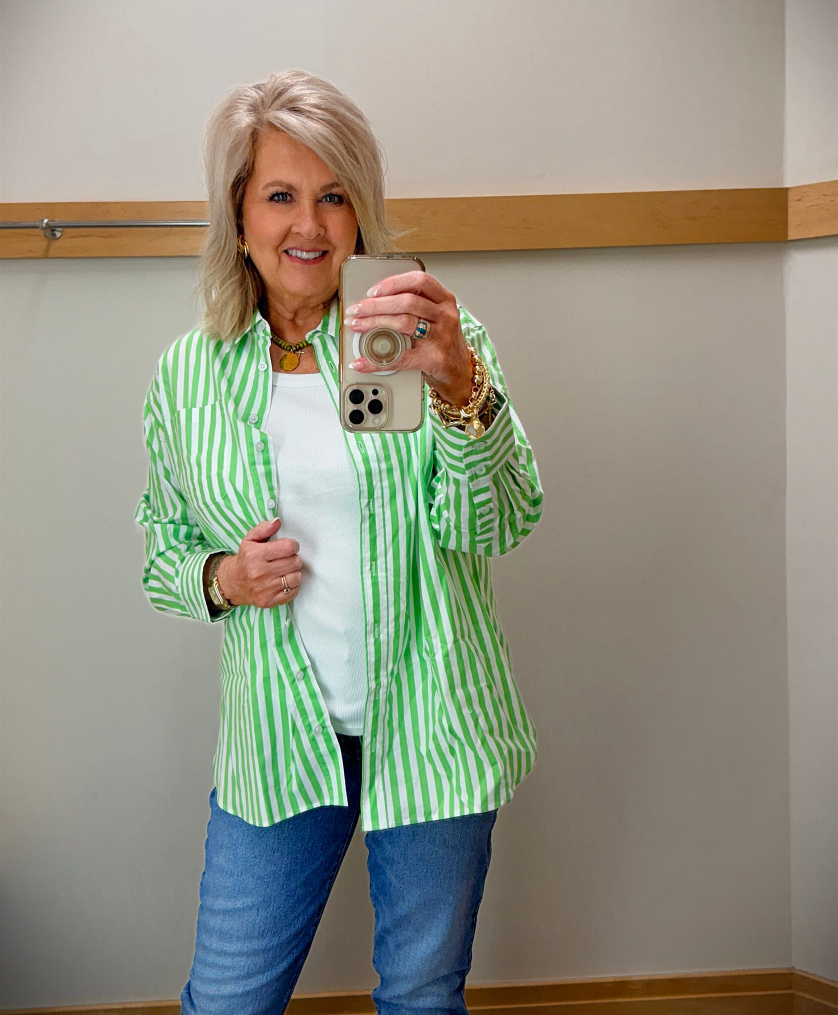 woman over 50 wearing green striped shirt with white tank