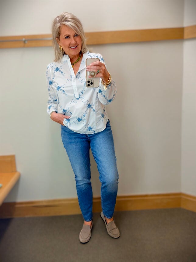 Tania wearing blue embroidered floral ruffle top with slim ankle jeans