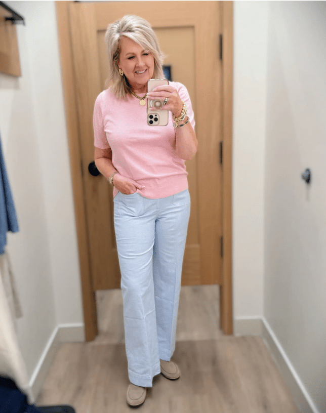 Tania wearing a pink sweater with striped light blue pants